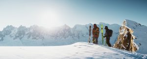 2 skiers at the top of a mountain admiring the landscape